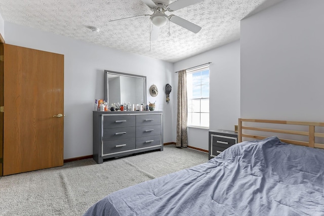 bedroom featuring ceiling fan, carpet floors, and a textured ceiling