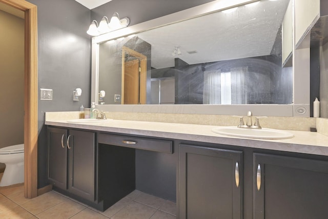 bathroom with tile patterned floors, vanity, toilet, and walk in shower