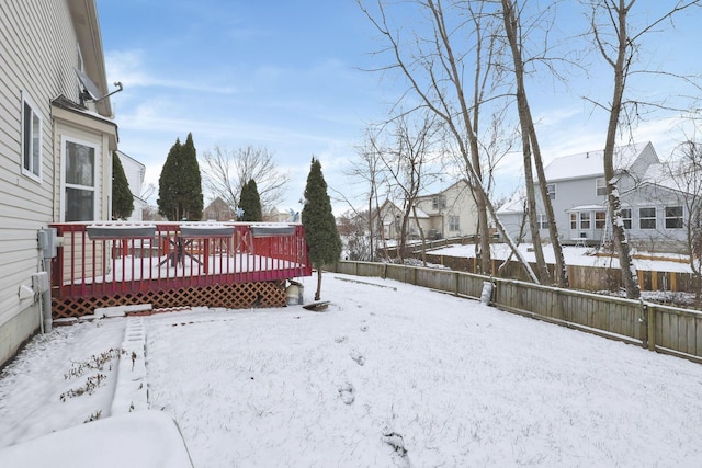 yard covered in snow with a deck