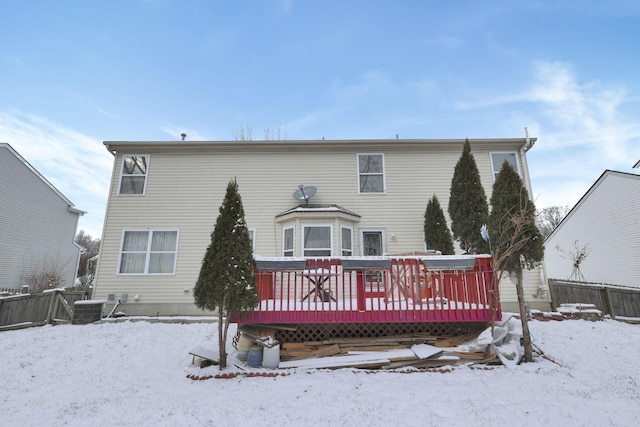 snow covered rear of property with central air condition unit and a wooden deck