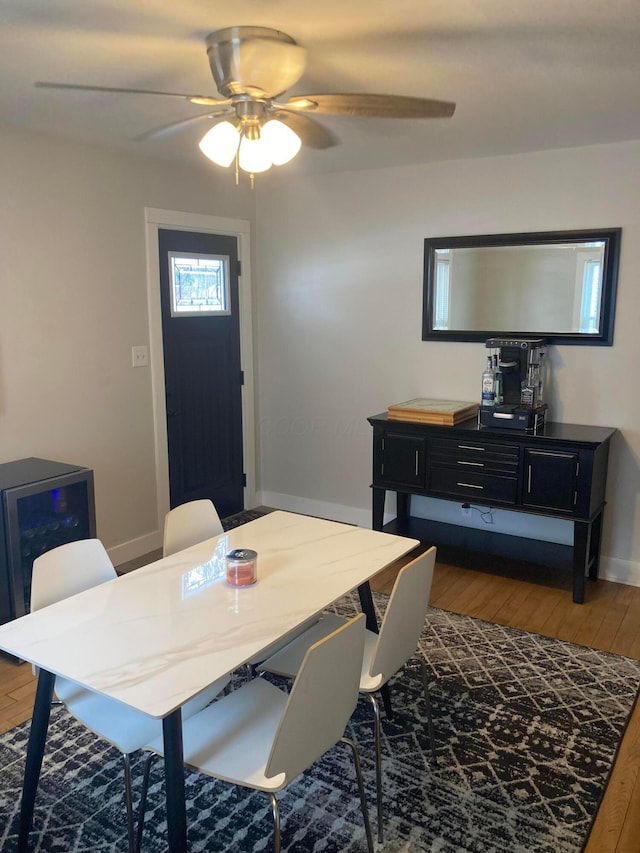 dining space with ceiling fan and dark wood-type flooring