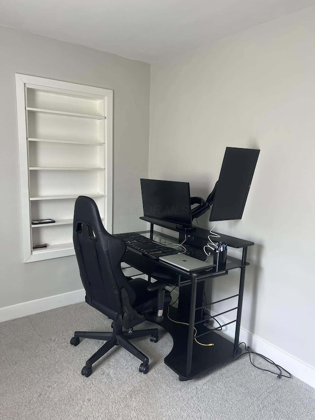 carpeted office featuring built in shelves