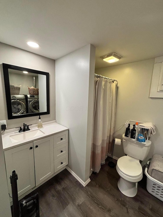 bathroom featuring curtained shower, separate washer and dryer, hardwood / wood-style floors, toilet, and vanity