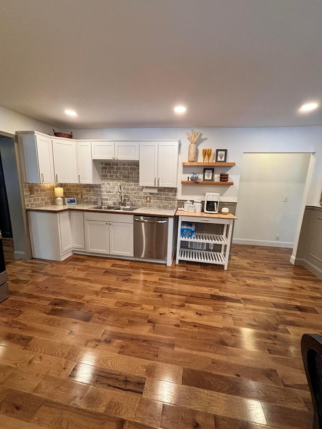 kitchen with stainless steel dishwasher, dark hardwood / wood-style flooring, white cabinets, and sink