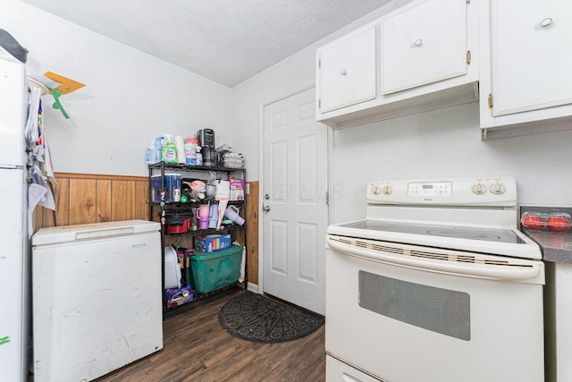 kitchen with white cabinetry, white electric range, dark wood-type flooring, and wooden walls