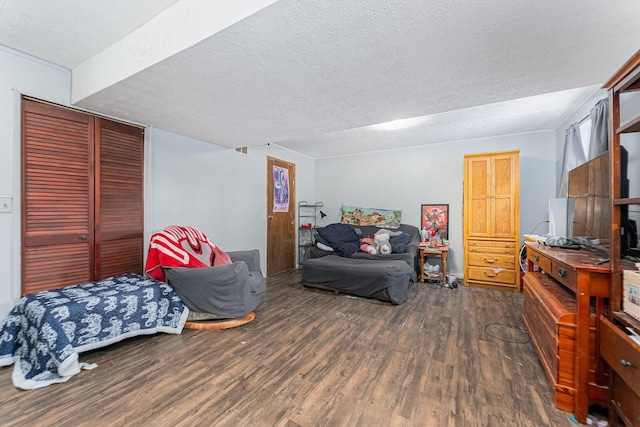 bedroom with a textured ceiling, dark hardwood / wood-style flooring, and a closet