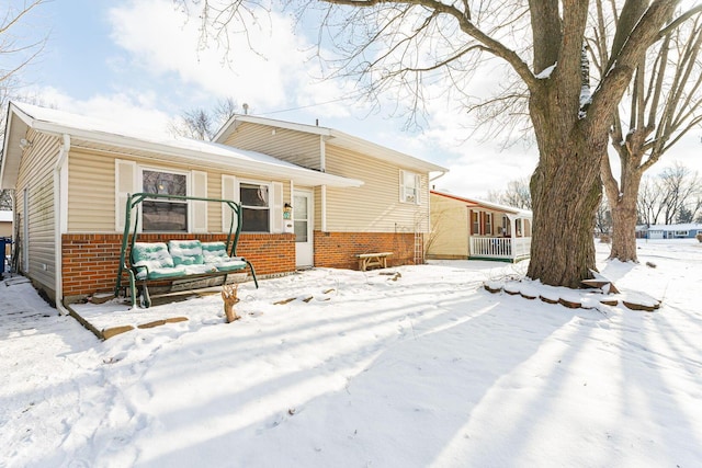 snow covered house with outdoor lounge area