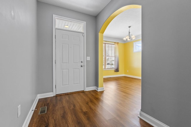 foyer entrance featuring dark hardwood / wood-style flooring and an inviting chandelier