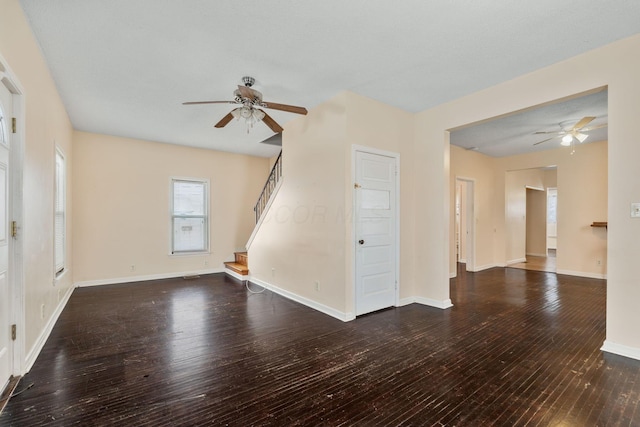 unfurnished living room featuring dark hardwood / wood-style floors and ceiling fan