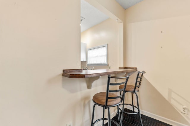 interior space featuring bar and a textured ceiling