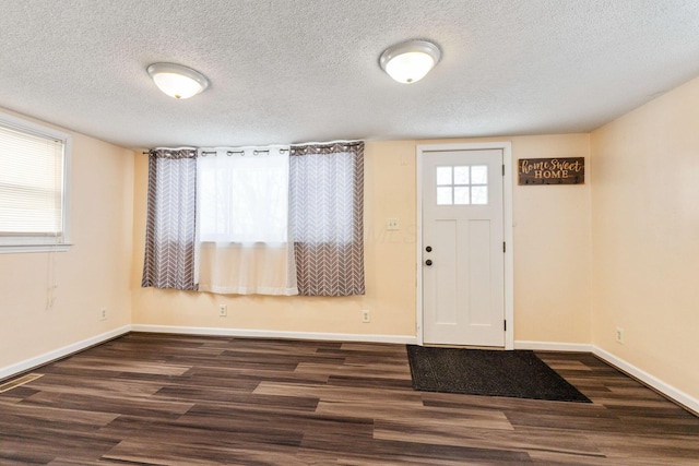 foyer featuring dark hardwood / wood-style flooring and a textured ceiling