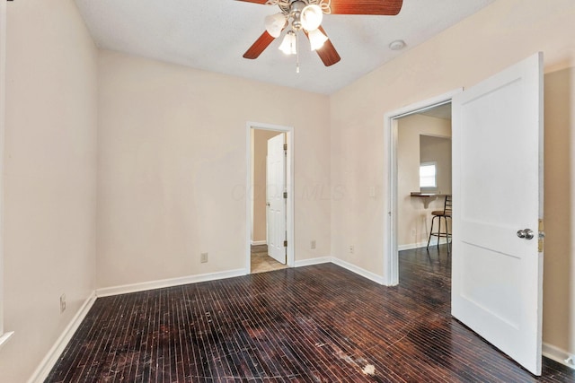 spare room featuring dark hardwood / wood-style flooring and ceiling fan