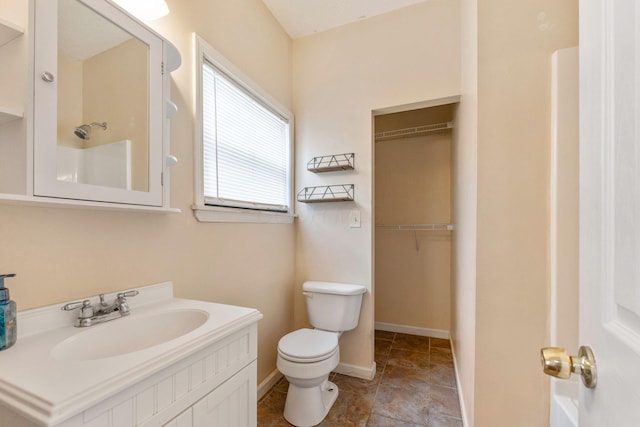 bathroom featuring walk in shower, vanity, and toilet