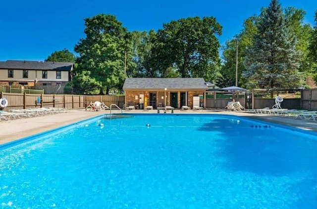 view of pool featuring an outbuilding and a patio