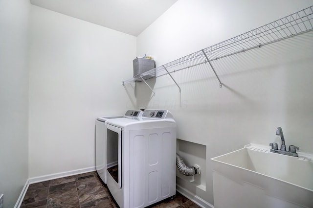 clothes washing area with separate washer and dryer and sink