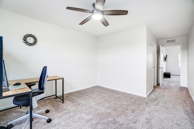 carpeted office space featuring ceiling fan