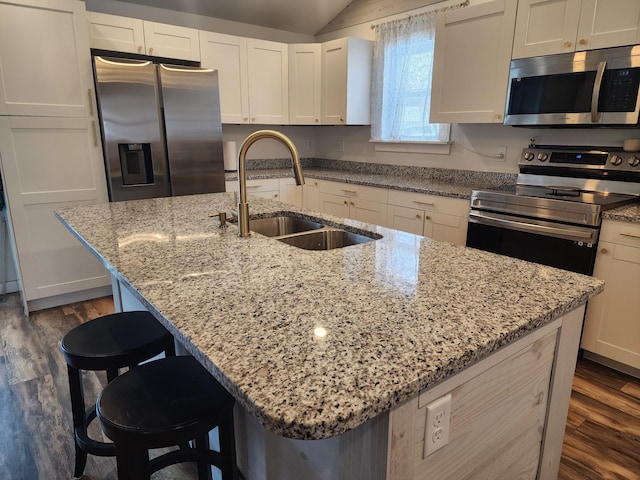 kitchen featuring appliances with stainless steel finishes, a kitchen island with sink, a kitchen breakfast bar, and sink