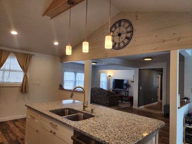 kitchen featuring pendant lighting, white cabinets, light stone counters, and sink