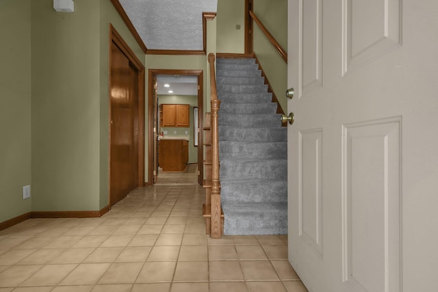 stairs featuring a textured ceiling and tile patterned floors