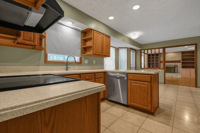 kitchen featuring kitchen peninsula, stainless steel dishwasher, extractor fan, a fireplace, and light tile patterned flooring