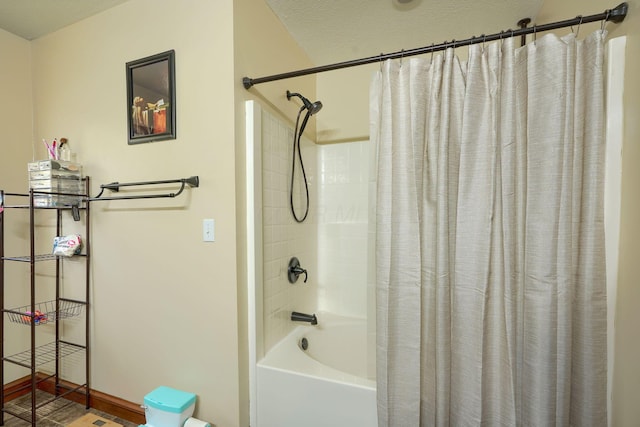 bathroom with a textured ceiling and shower / bath combo