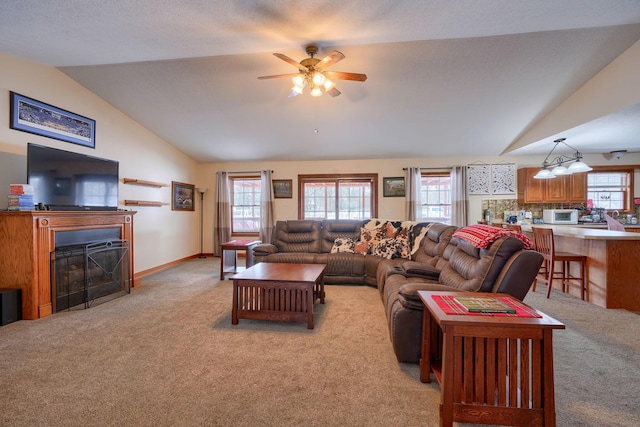 living room with ceiling fan, light colored carpet, and lofted ceiling