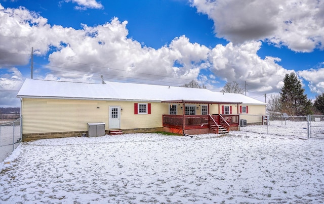 snow covered rear of property featuring cooling unit