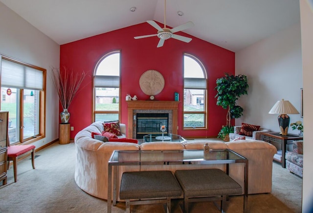 living room featuring a tiled fireplace, ceiling fan, light colored carpet, and vaulted ceiling