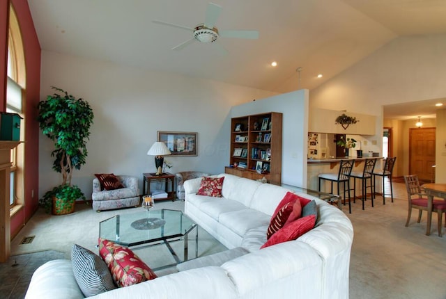 carpeted living room with ceiling fan and vaulted ceiling