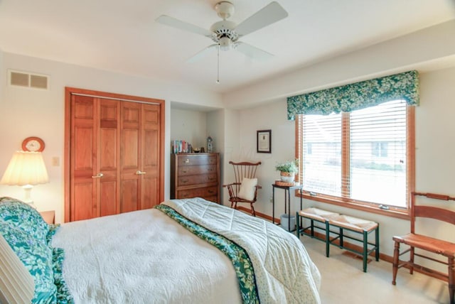 carpeted bedroom with ceiling fan and a closet