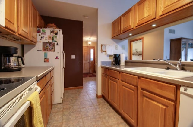 kitchen with white appliances, plenty of natural light, and sink