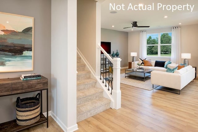 living room featuring light wood-style floors, recessed lighting, baseboards, and stairs