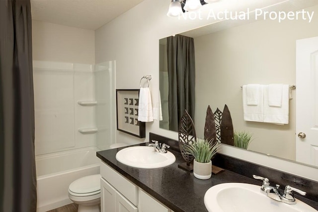 full bathroom featuring double vanity, tub / shower combination, a sink, and toilet