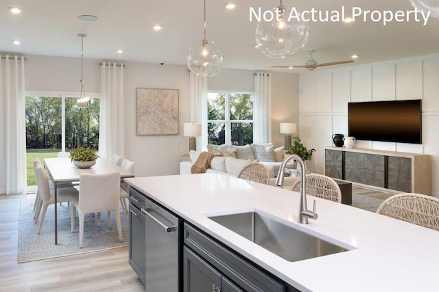 kitchen with ceiling fan, light wood-type flooring, dishwasher, pendant lighting, and sink