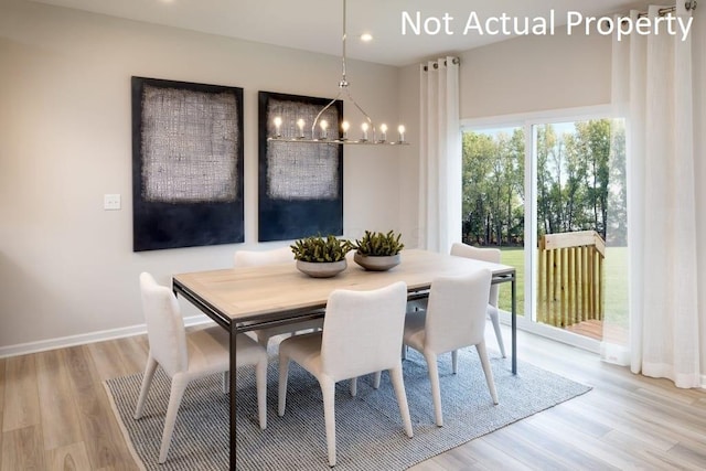 dining room with light hardwood / wood-style floors and a notable chandelier