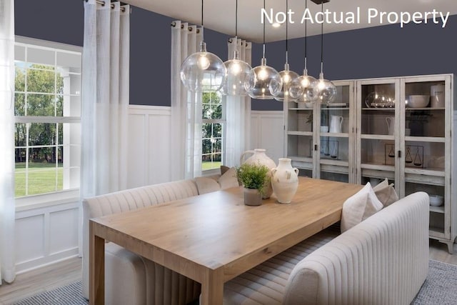 dining room featuring breakfast area, wood-type flooring, and plenty of natural light