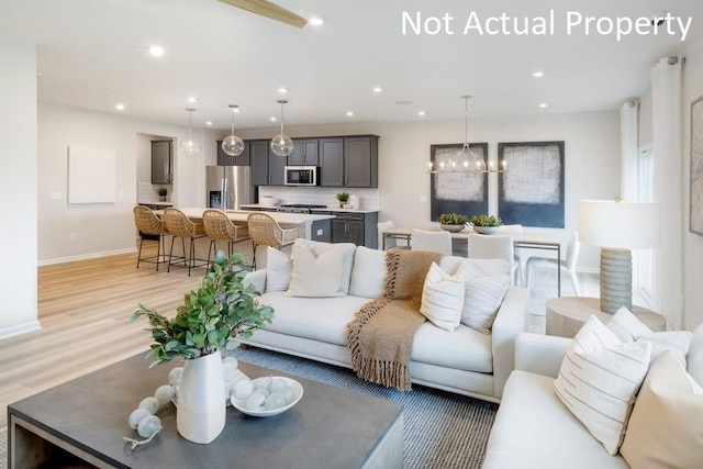 living room with an inviting chandelier and light hardwood / wood-style flooring