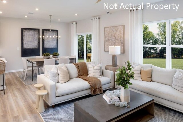 living room with light hardwood / wood-style flooring and an inviting chandelier