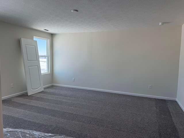 carpeted empty room with a textured ceiling