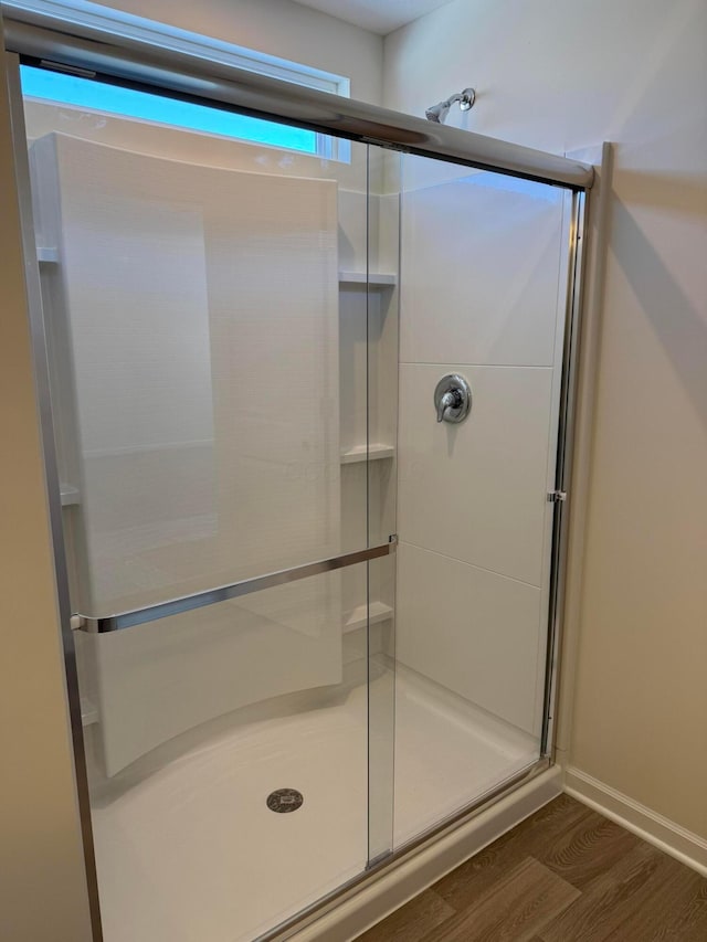 bathroom featuring walk in shower and wood-type flooring