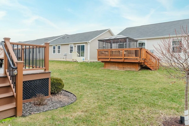 rear view of property featuring a deck and a lawn