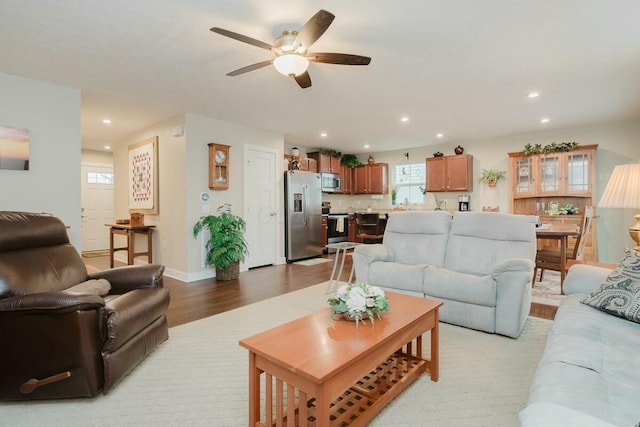 living room featuring ceiling fan and light wood-type flooring