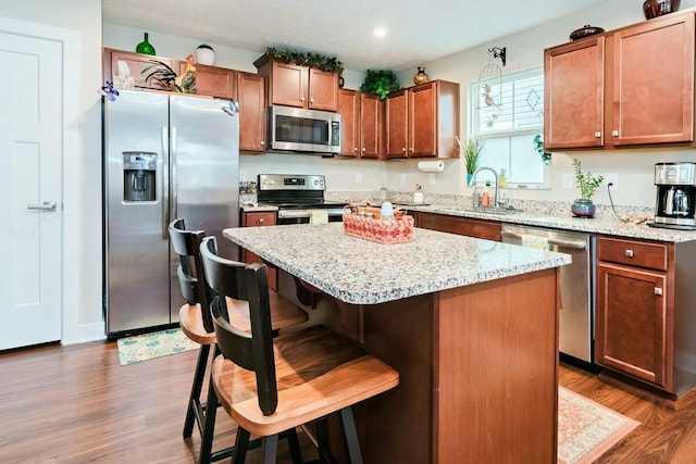 kitchen featuring a kitchen bar, dark hardwood / wood-style flooring, a kitchen island, and appliances with stainless steel finishes