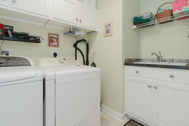 laundry area featuring washer and clothes dryer, cabinets, and sink