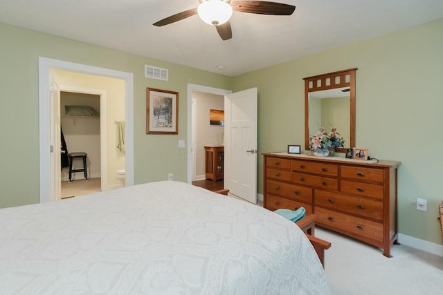 bedroom with ensuite bathroom, ceiling fan, and light colored carpet