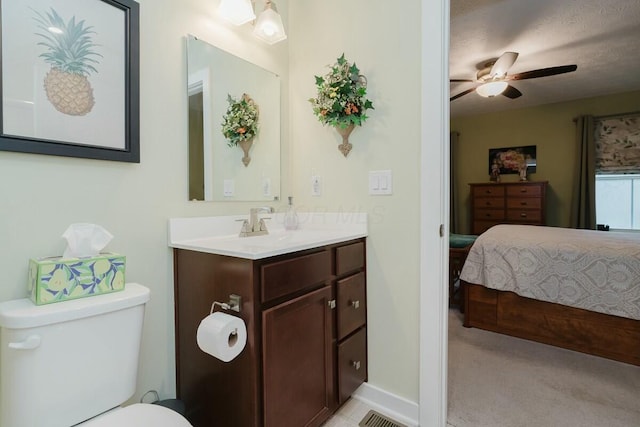 bathroom featuring vanity, a textured ceiling, toilet, and ceiling fan