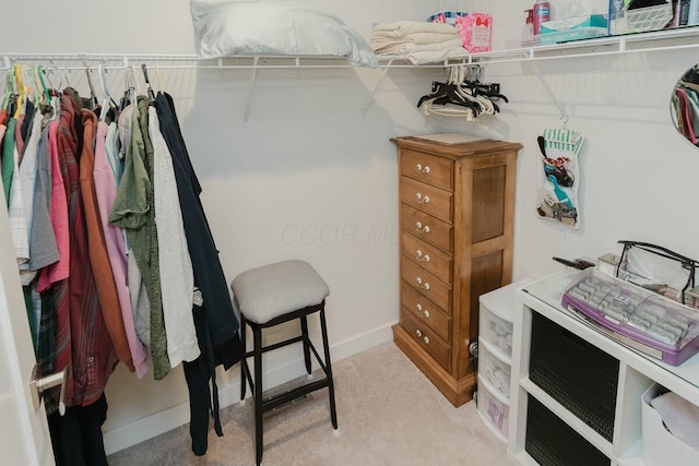 walk in closet featuring light colored carpet