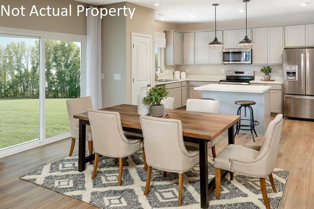 dining room with recessed lighting and light wood finished floors