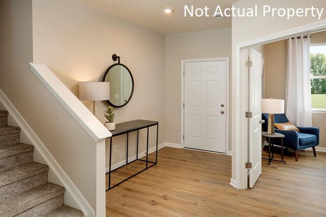 entryway with stairway, baseboards, and wood finished floors