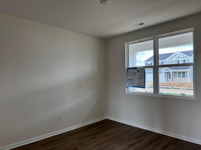 empty room with dark wood-style floors and baseboards